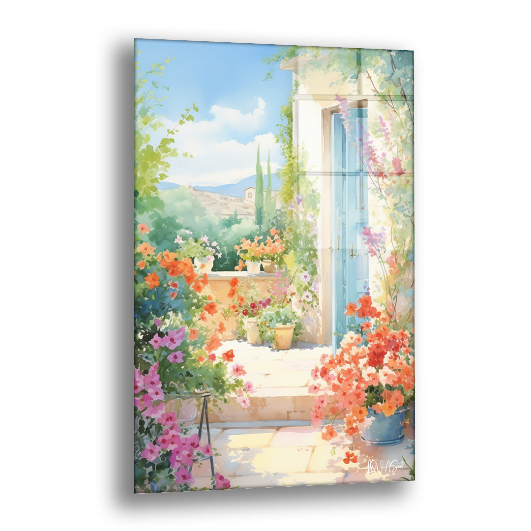 Çiçekli Avlu Kapısı cam tablo — açık mavi bir kapının ve taşan çiçek saksılarının uzak dağlara açılan bir avluyu süslediği fe